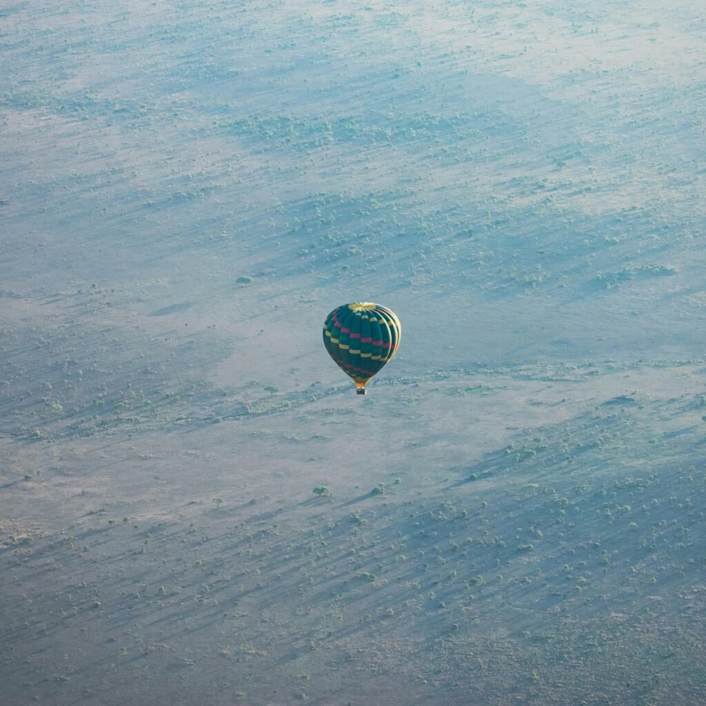 A hot air balloon floating over the expansive Serengeti National Park, showcasing aerial tranquility.
