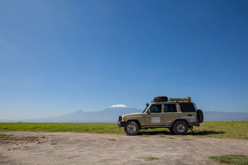 Toyota Land Cruiser on open terrain with Mount Kilimanjaro in the distance.